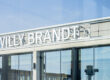 Außenansicht der Glasfassade des Terminal 1 am Flughafen BER mit dem Schriftzug "Willy Brandt"