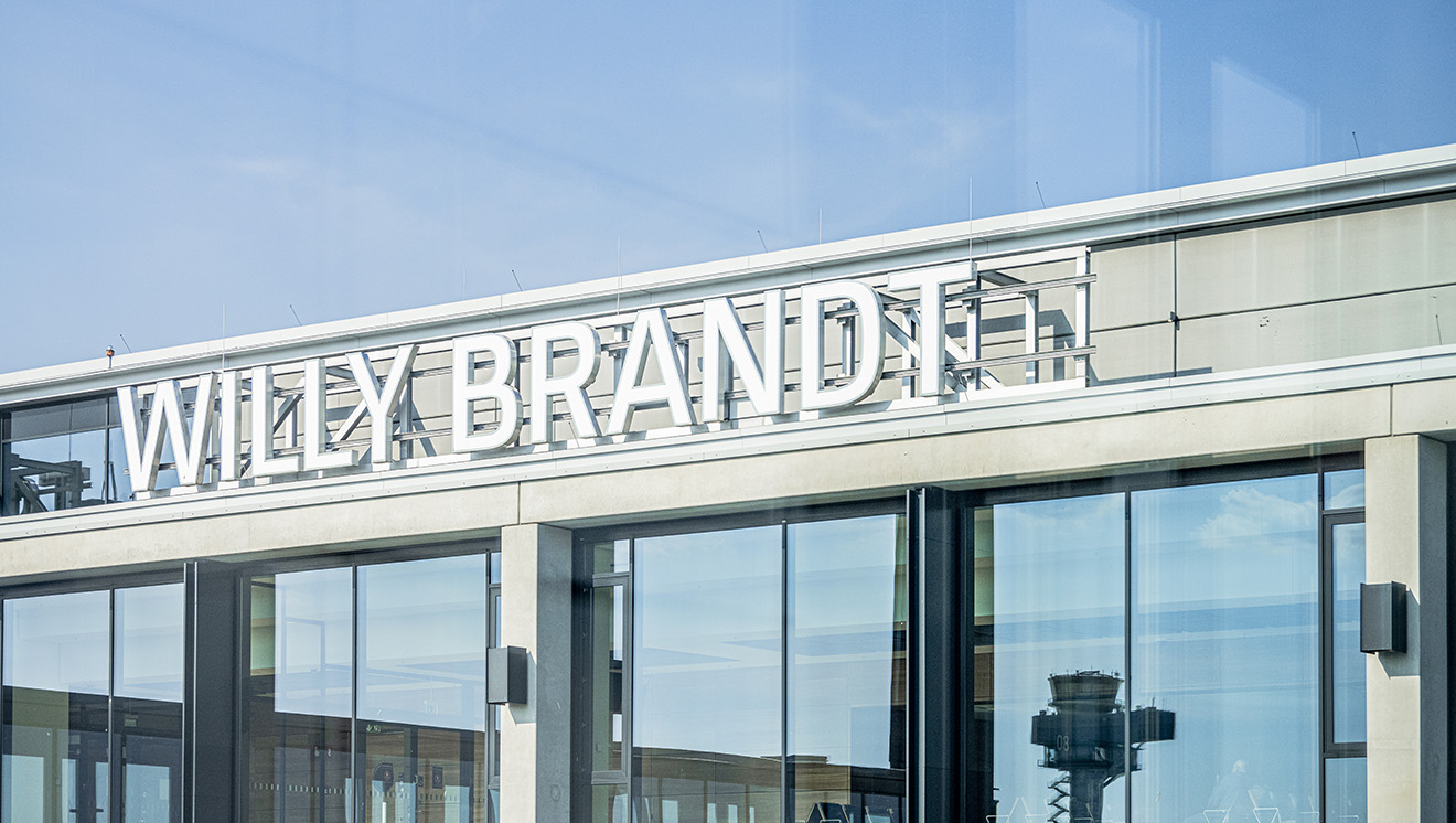 Außenansicht der Glasfassade des Terminal 1 am Flughafen BER mit dem Schriftzug "Willy Brandt"