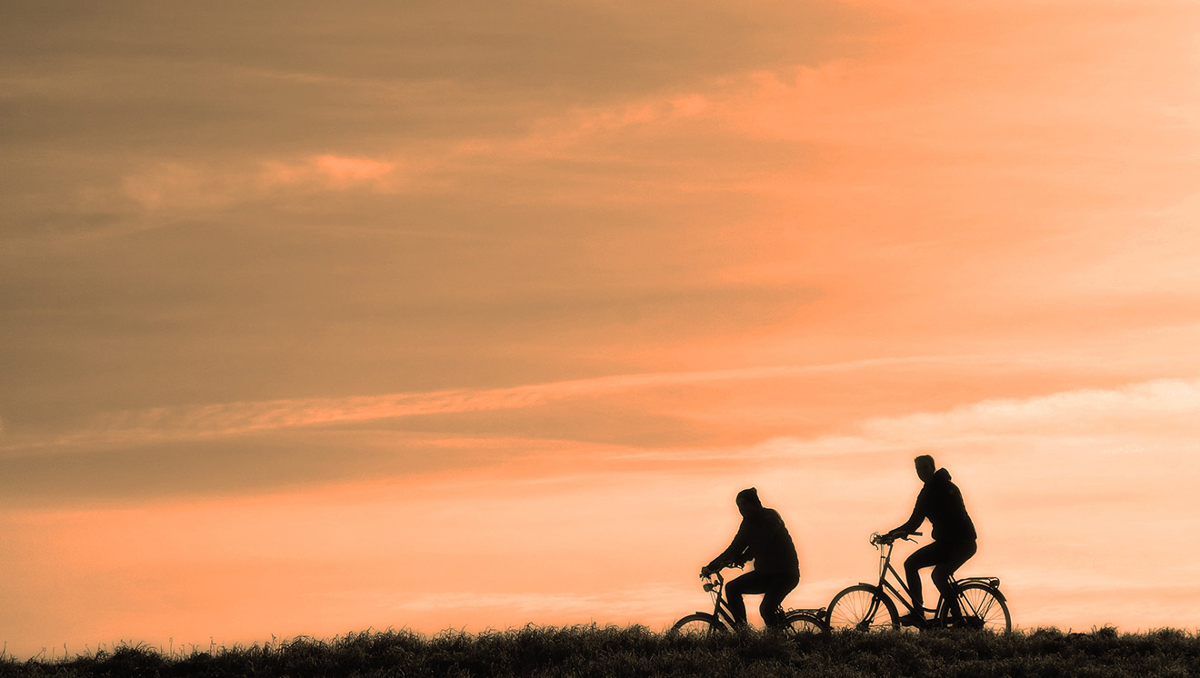 Zwei Radfahrende beim Sonnenuntergang
